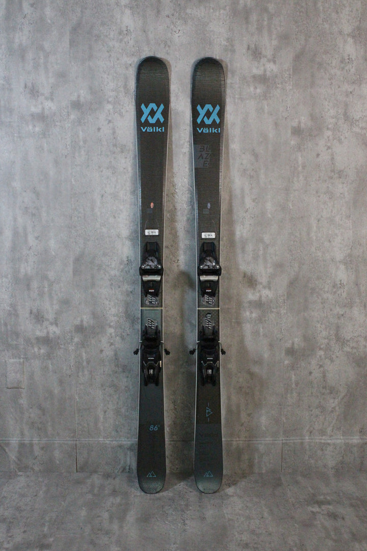 The Blaze 86 W offers lightness, versatility, and agility, excelling in quick turns and varied terrain. Its three-radius sidecut, suspension tips and tails, and lightweight wood core make it ideal for backcountry skiing. It handles ascents and descents well but may struggle in deep snow. Available as used skis in Park City.